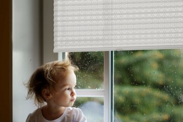 Adorable toddler girl looking though the window